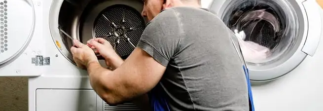 Dryer repair technician fixing a clothes dryer drum in Pueblo, CO