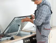 Appliance repair technician installing a built-in cooktop in Pueblo, CO