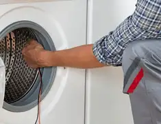 Dryer repair technician diagnosing and servicing a clothes dryer in Pueblo, CO