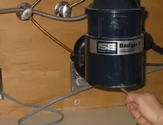 Garbage disposal repair technician tightening the mounting ring under a sink in Pueblo, CO