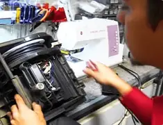 Vacuum repair technician servicing internal components on a workbench in Pueblo, CO