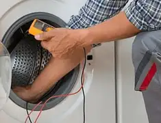 Washing machine repair technician testing a front-load washer with diagnostic tools in Pueblo, CO