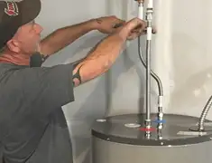 Water heater repair technician tightening supply line connections in Pueblo, CO